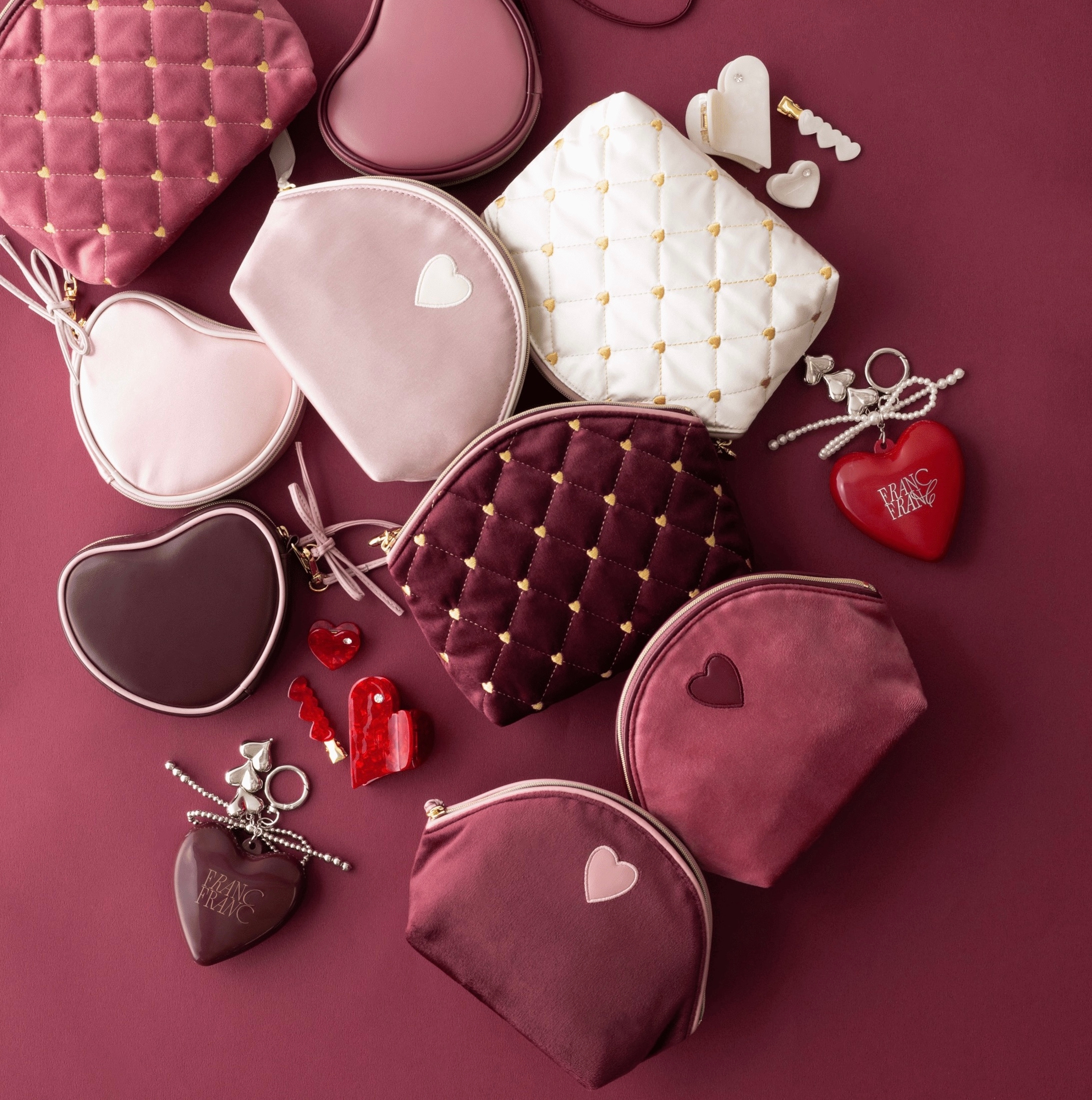 さまざまな形やサイズのハート模様がついた化粧ポーチとアクセサリーが並べられている。