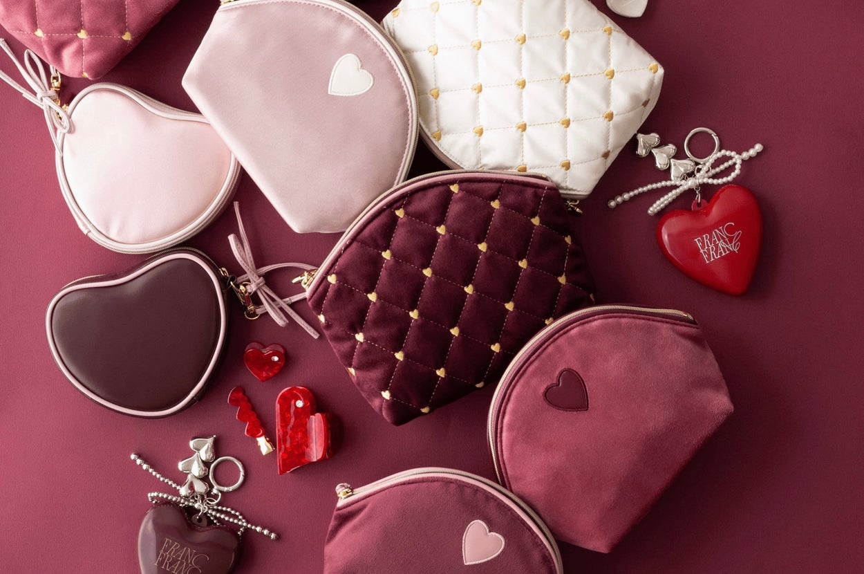 さまざまな形やサイズのハート模様がついた化粧ポーチとアクセサリーが並べられている。