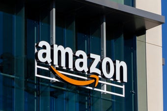 青空を背景にしたAmazonのオフィスビルの外観。ブランドロゴが建物のガラス面に表示されている。
