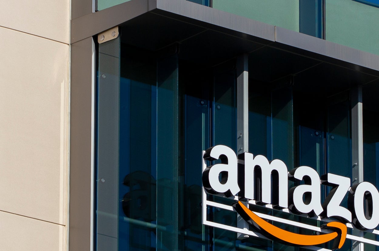 青空を背景にしたAmazonのオフィスビルの外観。ブランドロゴが建物のガラス面に表示されている。