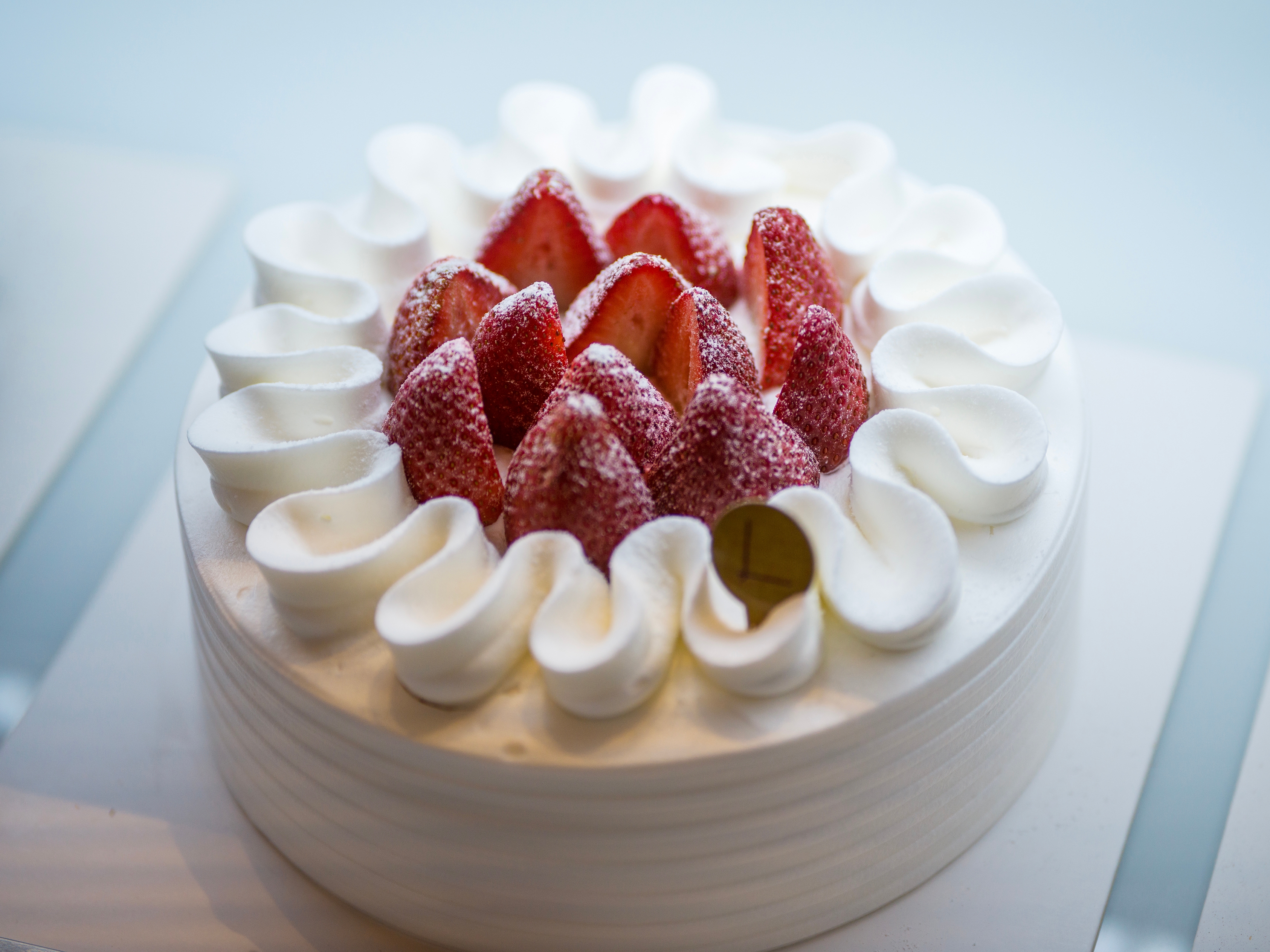 イチゴとクリームがのったデコレーションケーキが、白いプレートに置かれている。