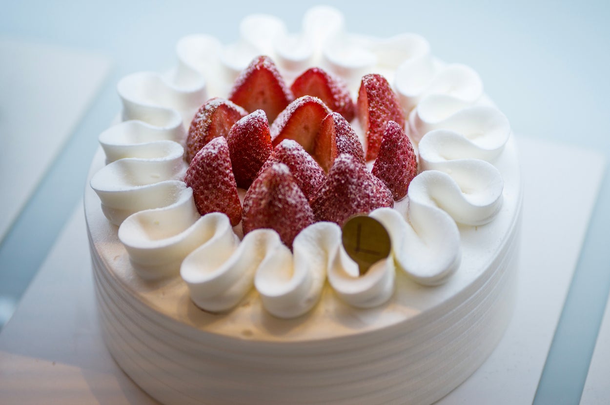 イチゴとクリームがのったデコレーションケーキが、白いプレートに置かれている。