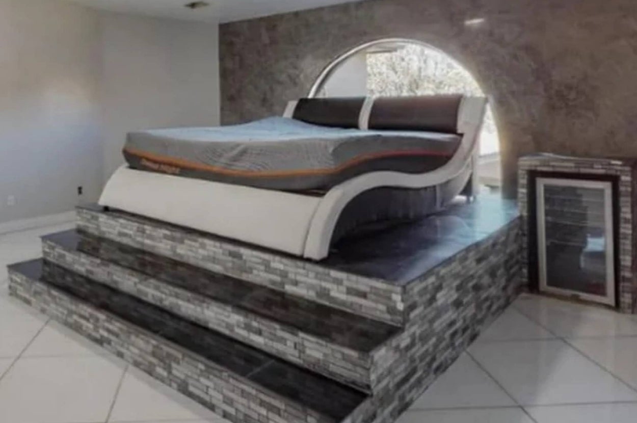Futuristic bed on a raised platform with stairs