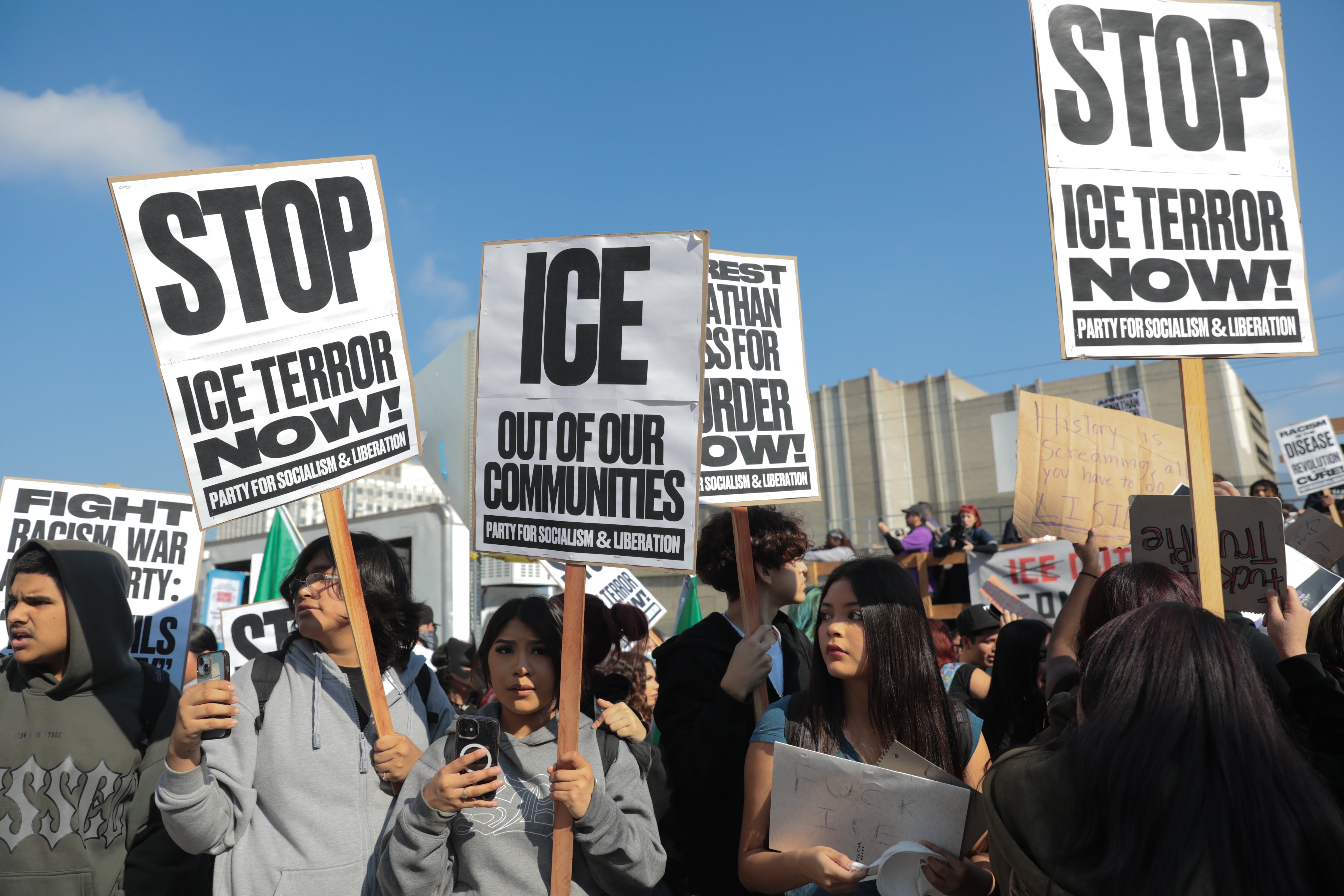 Folk protesterer med skilt som motsetter seg ICE og tar til orde for innvandringsreform