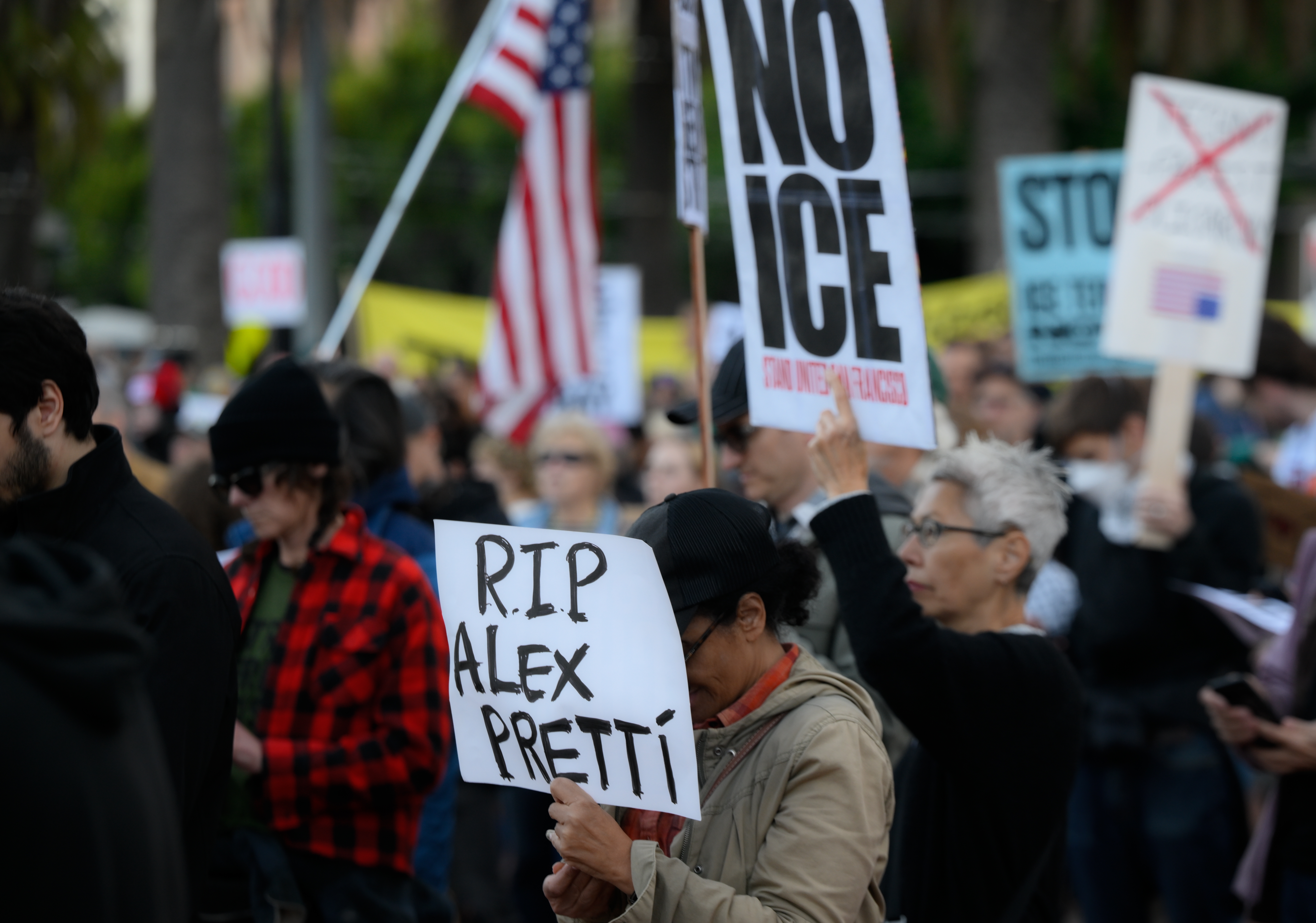 Demonstranter ved en demonstrasjon holder skilt, inkludert en som leser RIP Alex Pretti blant andre demonstranter som viser forskjellige meldinger