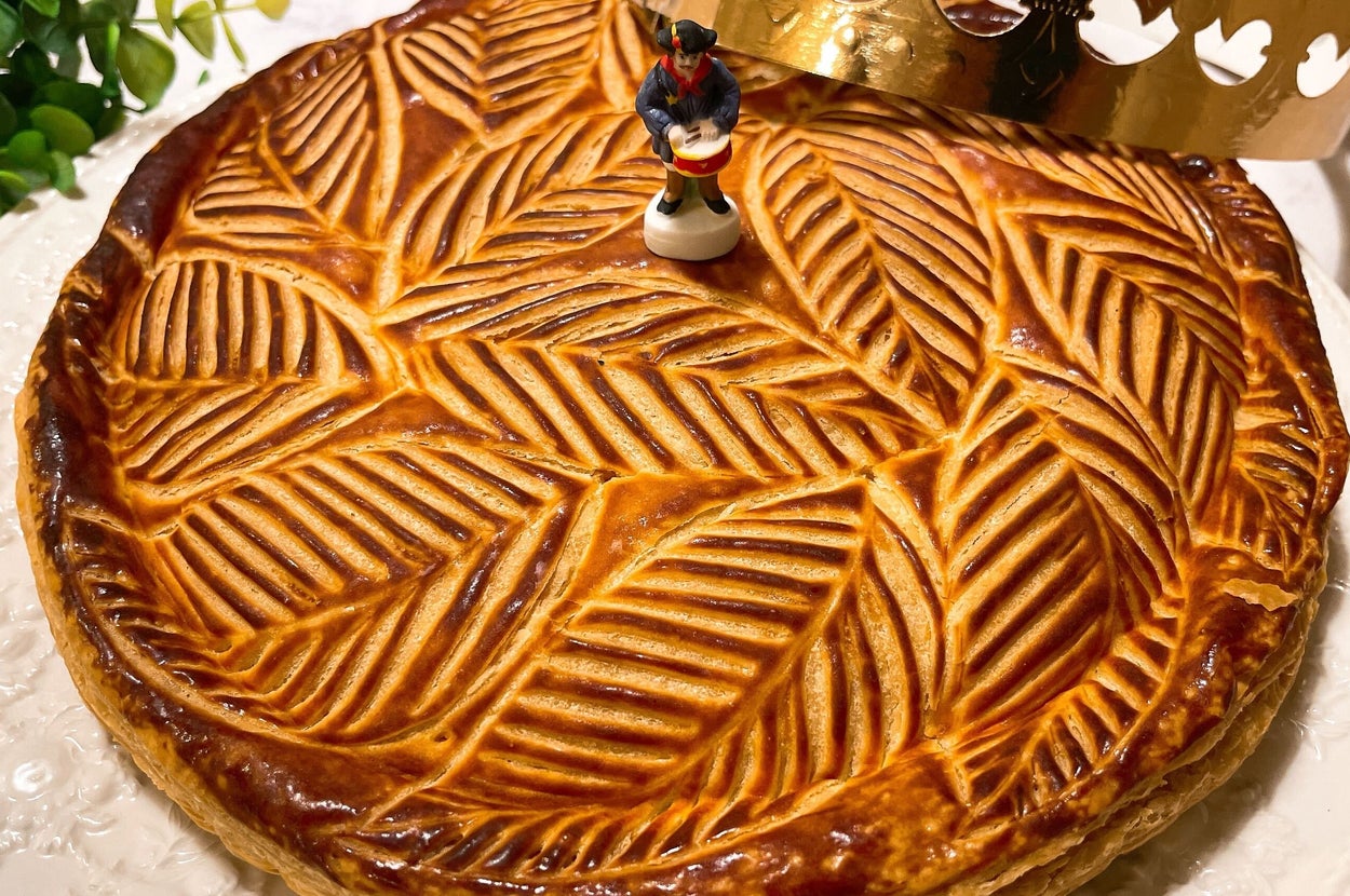 ガレット・デ・ロワに置かれた王冠と人形が飾られています。