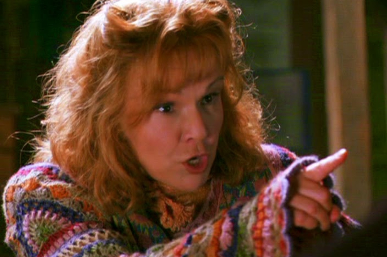 Mrs. Weasley pointing and looking stern while wearing a knit sweater