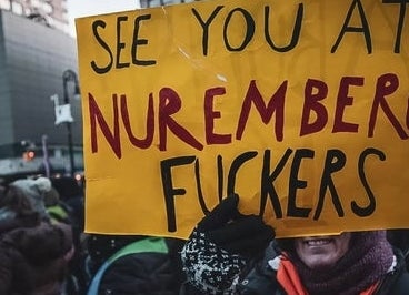 En person holder et protestskilt med teksten 