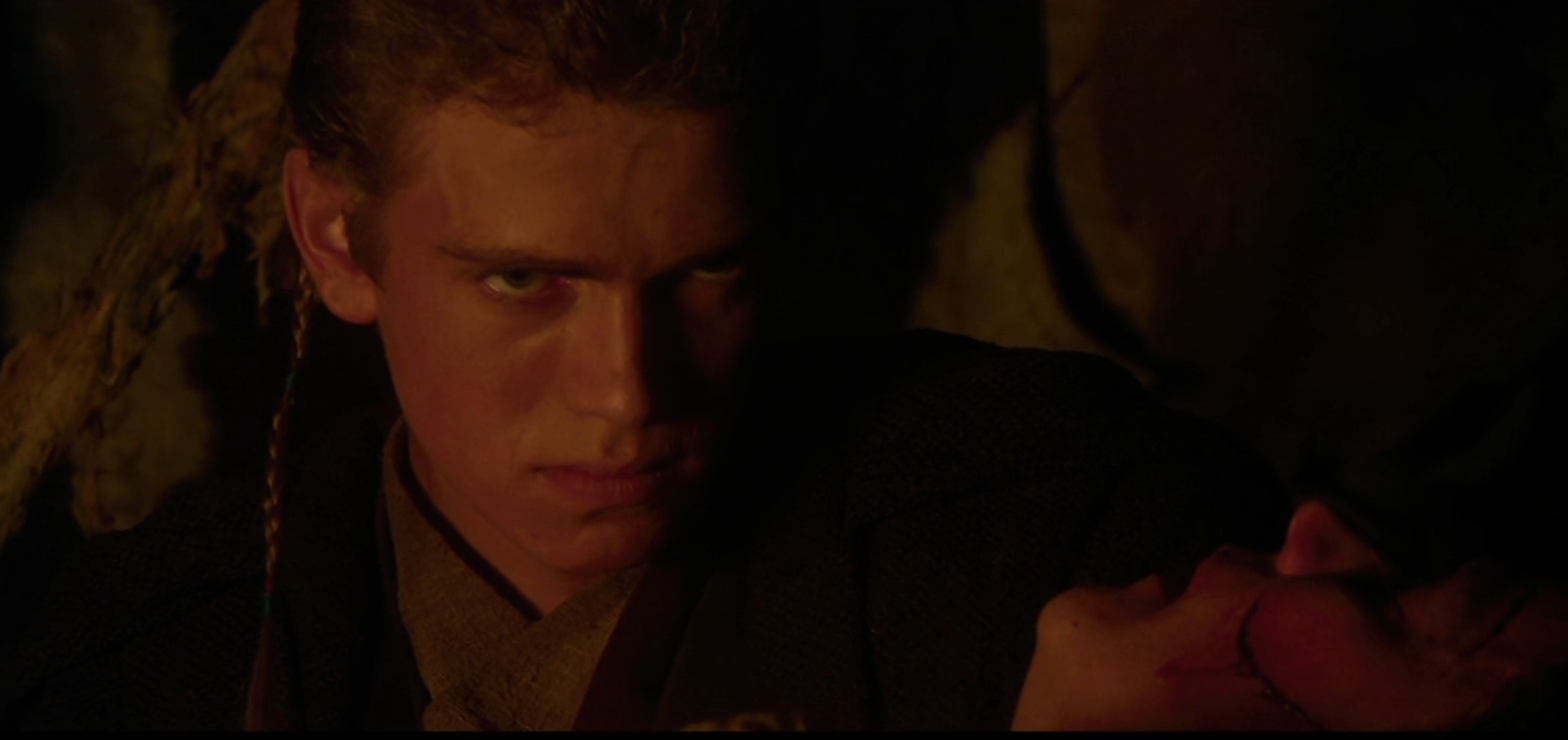 Scene from a movie featuring a young man with a serious expression, holding someone. The setting appears dramatic and tense