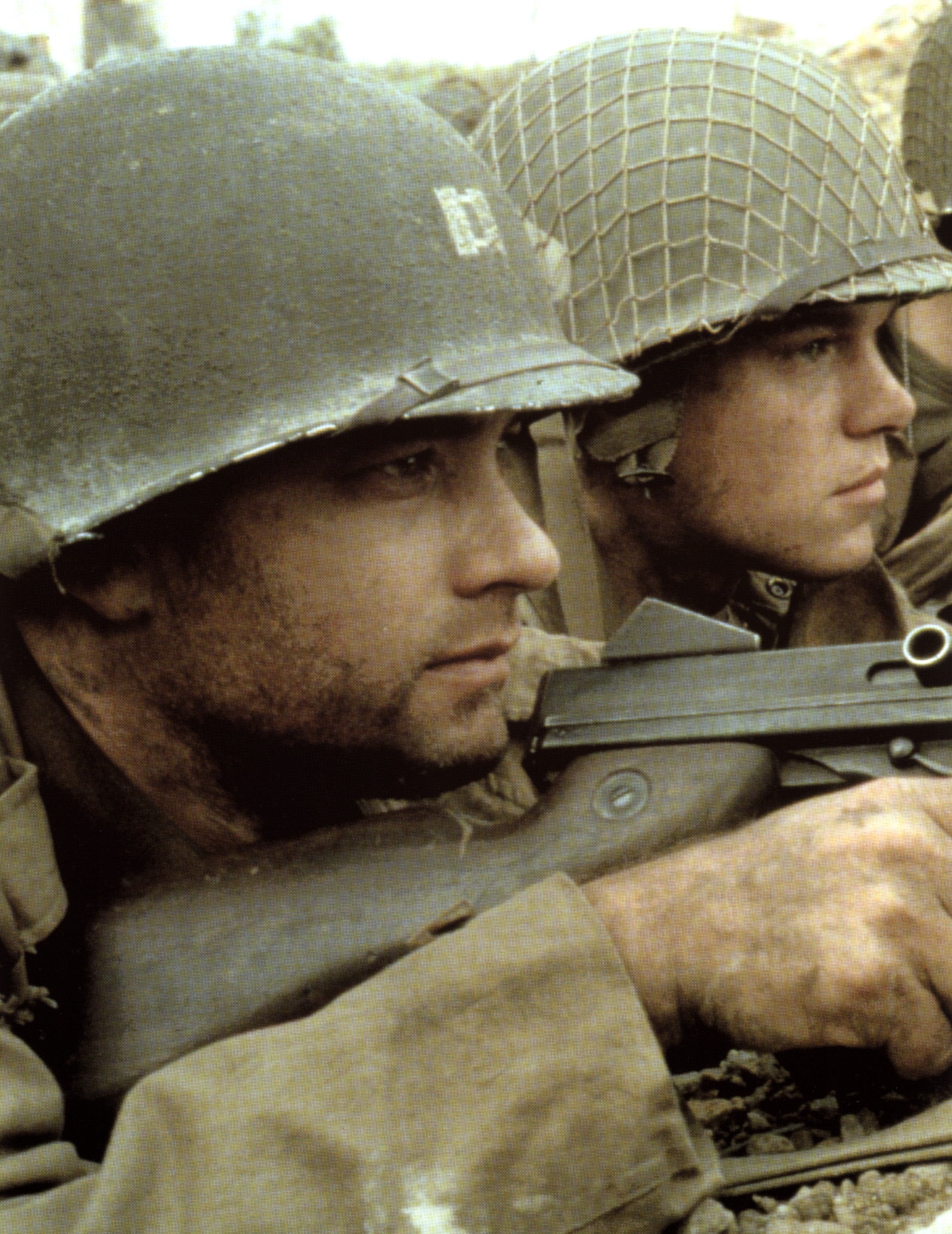 Two soldiers wearing helmets and military gear crouch with focus, aiming rifles, representing a scene from a war movie