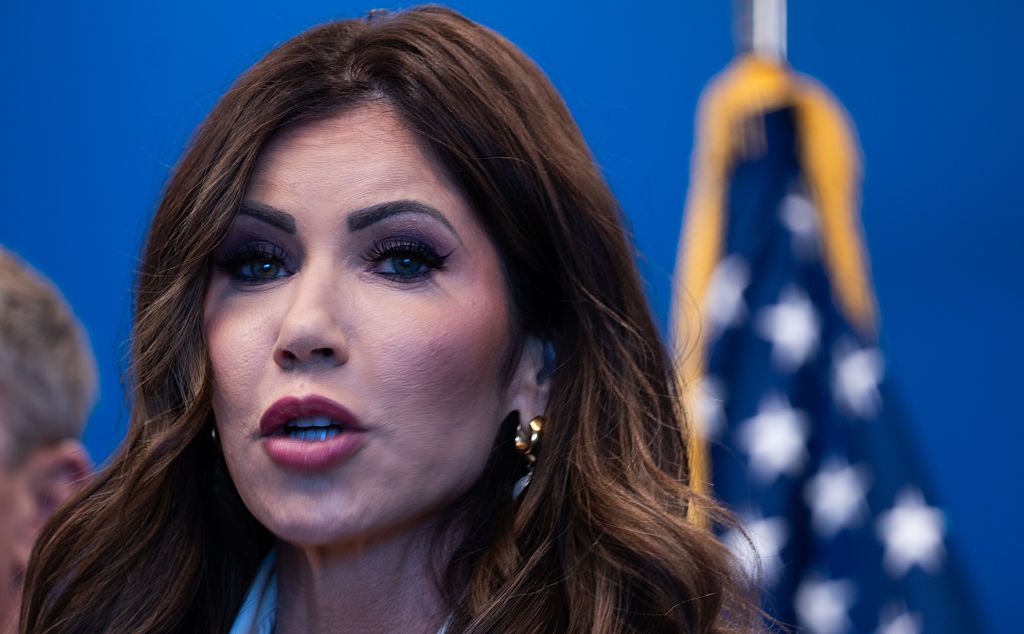 I don’t know who this person is, but they are speaking with an American flag in the background