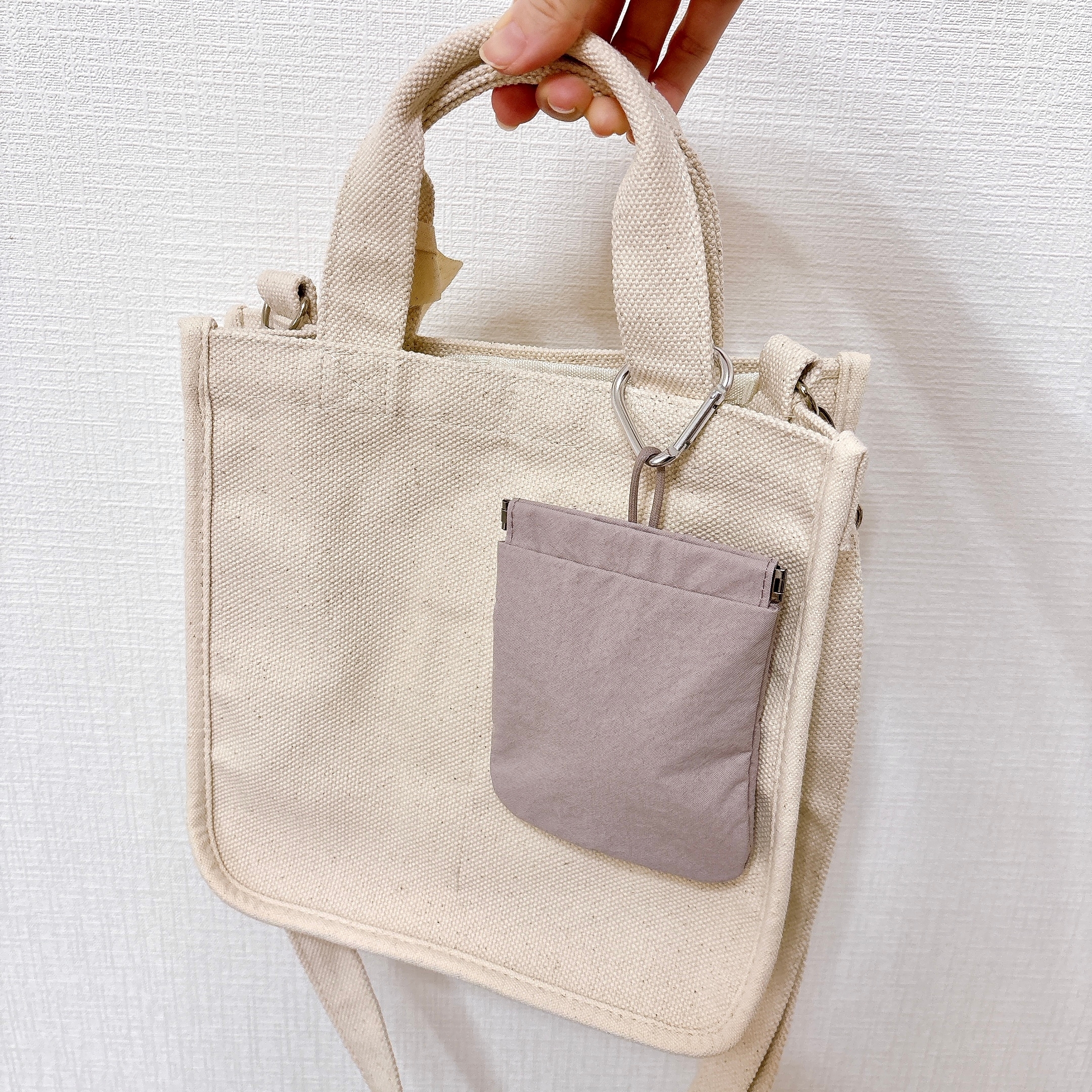 無印良品の「リンクルナイロン 片手で開くフラットポーチ」布製トートバッグにカラビナで取り付けている様子