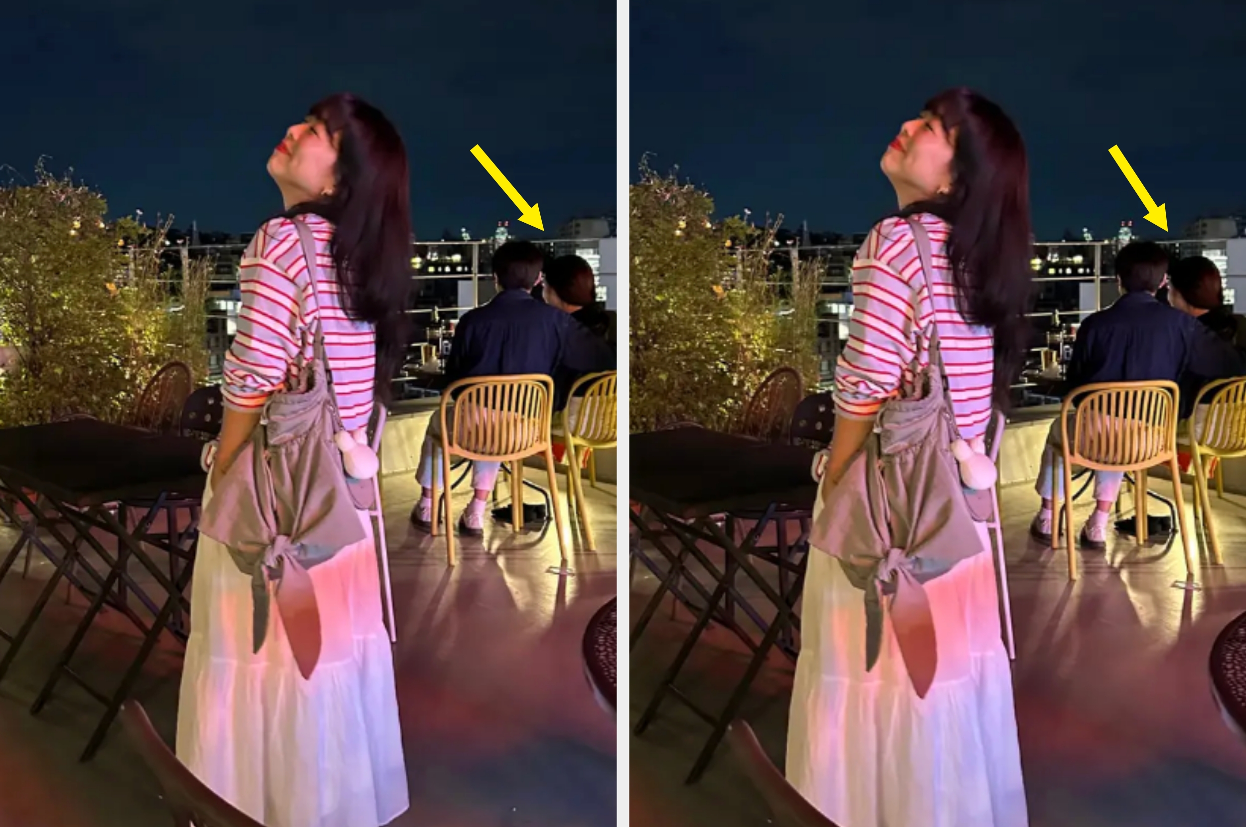 Person on a rooftop terrace at night, facing upwards, wearing a striped shirt and skirt. Two people sit at a table in the background