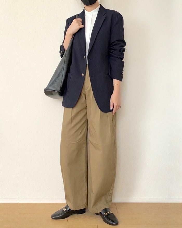 GU（ジーユー）の「チノタックバレルパンツQ」女性が白シャツ、ネイビーのブレザー、ベージュのワイドパンツ、ローファーを着用。