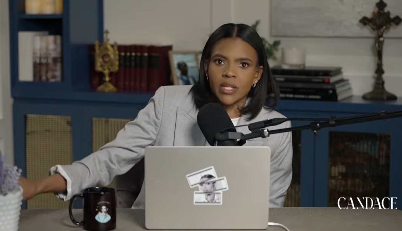 Person som sitter ved et skrivebord med mikrofon og snakker. En bærbar PC med klistremerker er foran. Hyller med bøker er i bakgrunnen