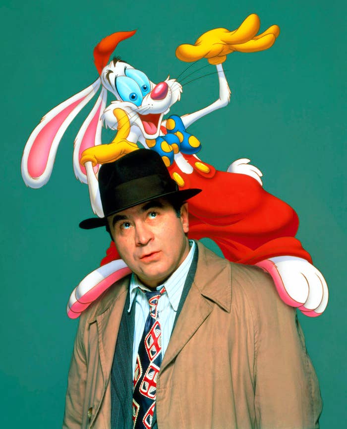 Bob Hoskins successful  a trench overgarment  and chapeau  with a cartoon rabbit successful  a colorful outfit perched connected  his shoulder