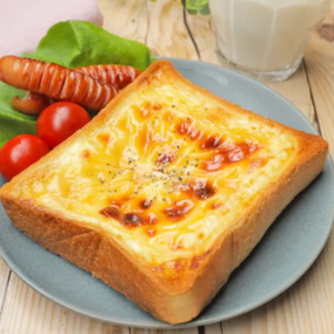 厚切りトーストにチーズとソーセージ、トマト、レタス、牛乳が添えられた食事。