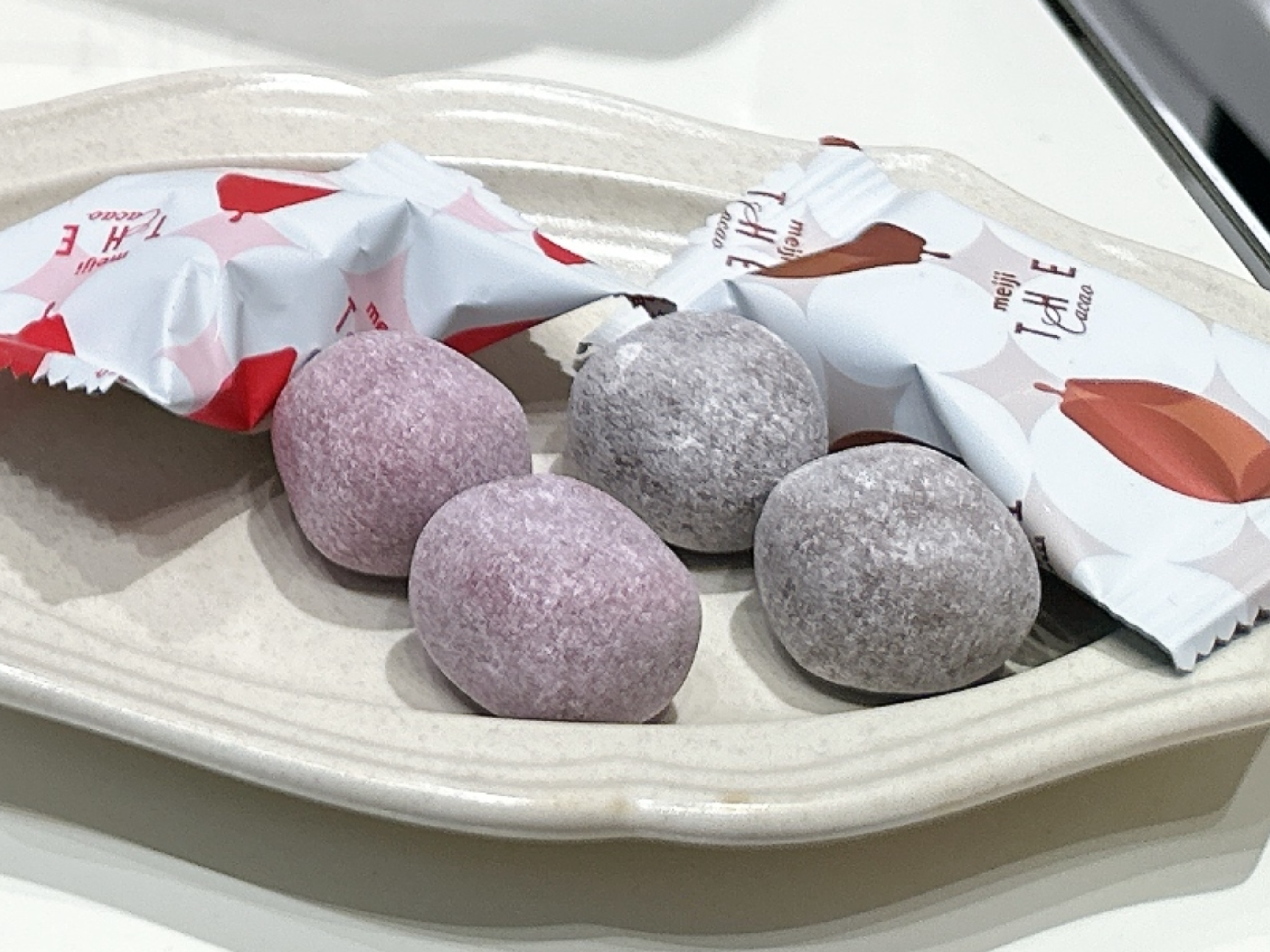 皿にのった4つの包まれたチョコレート。開封された包装紙が見えます。