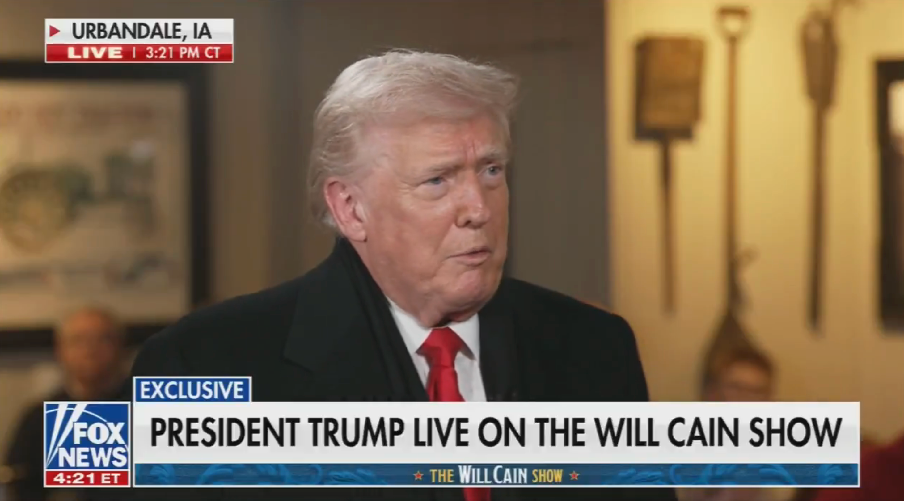 En mann i dress snakker i et intervju i et TV-program med overskriften