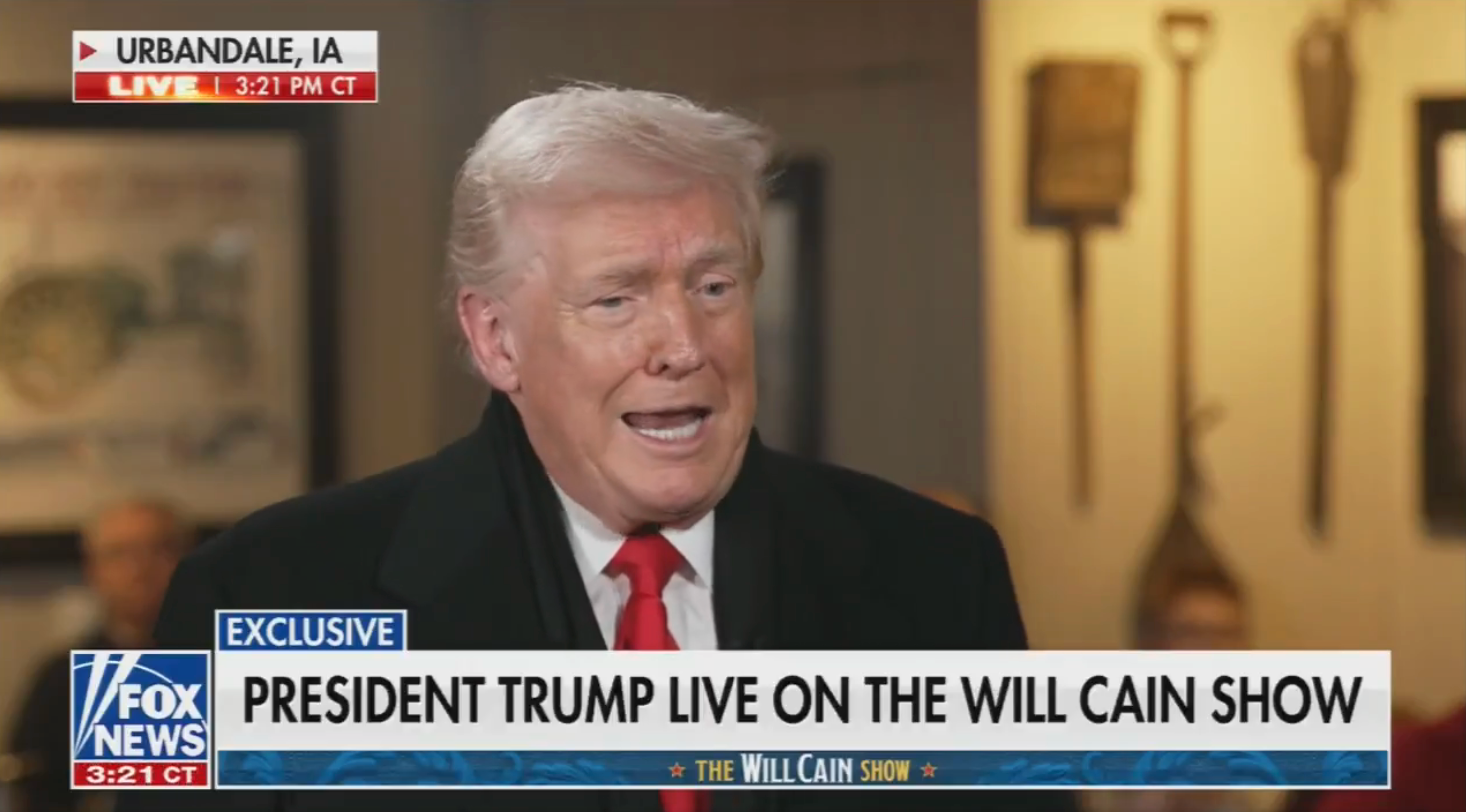 En mann i dress og rødt slips gir et intervju på The Will Cain Show. Tekst på skjermen indikerer plasseringen som Urbandale, IA