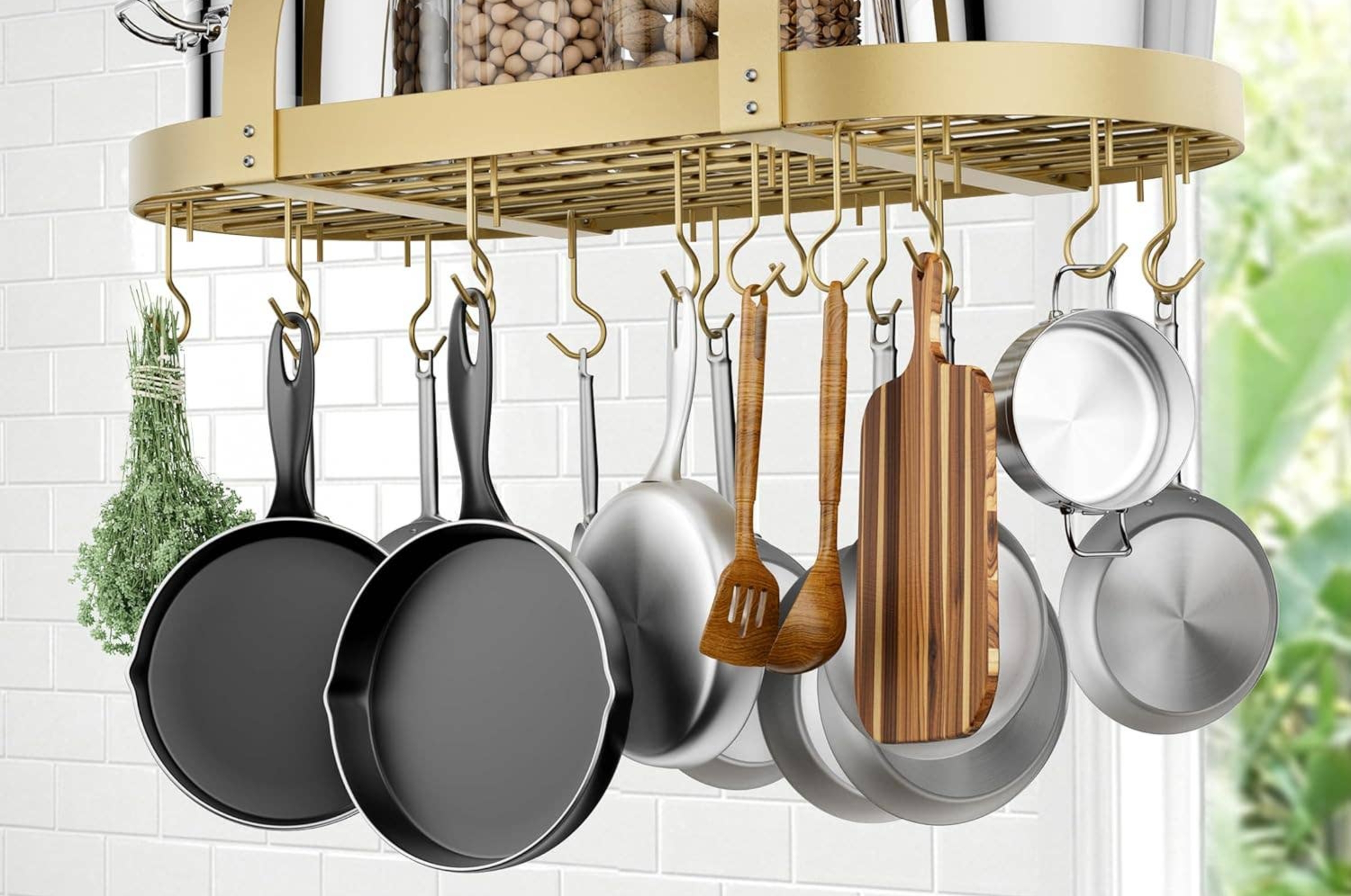 Hanging pot rack with cookware, jars, and a cutting board, displayed in a modern kitchen setting
