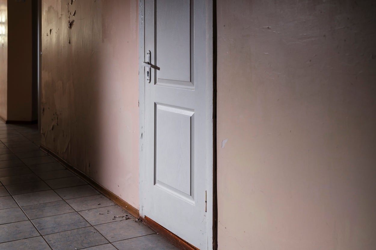 廊下に面した閉じた白いドアがある室内の風景。シンプルなドアデザイン。