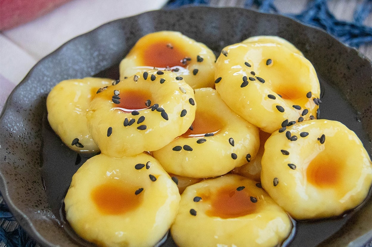 お皿にのったさつまいも白玉のみたらしあん。黒いりごまがのっている。