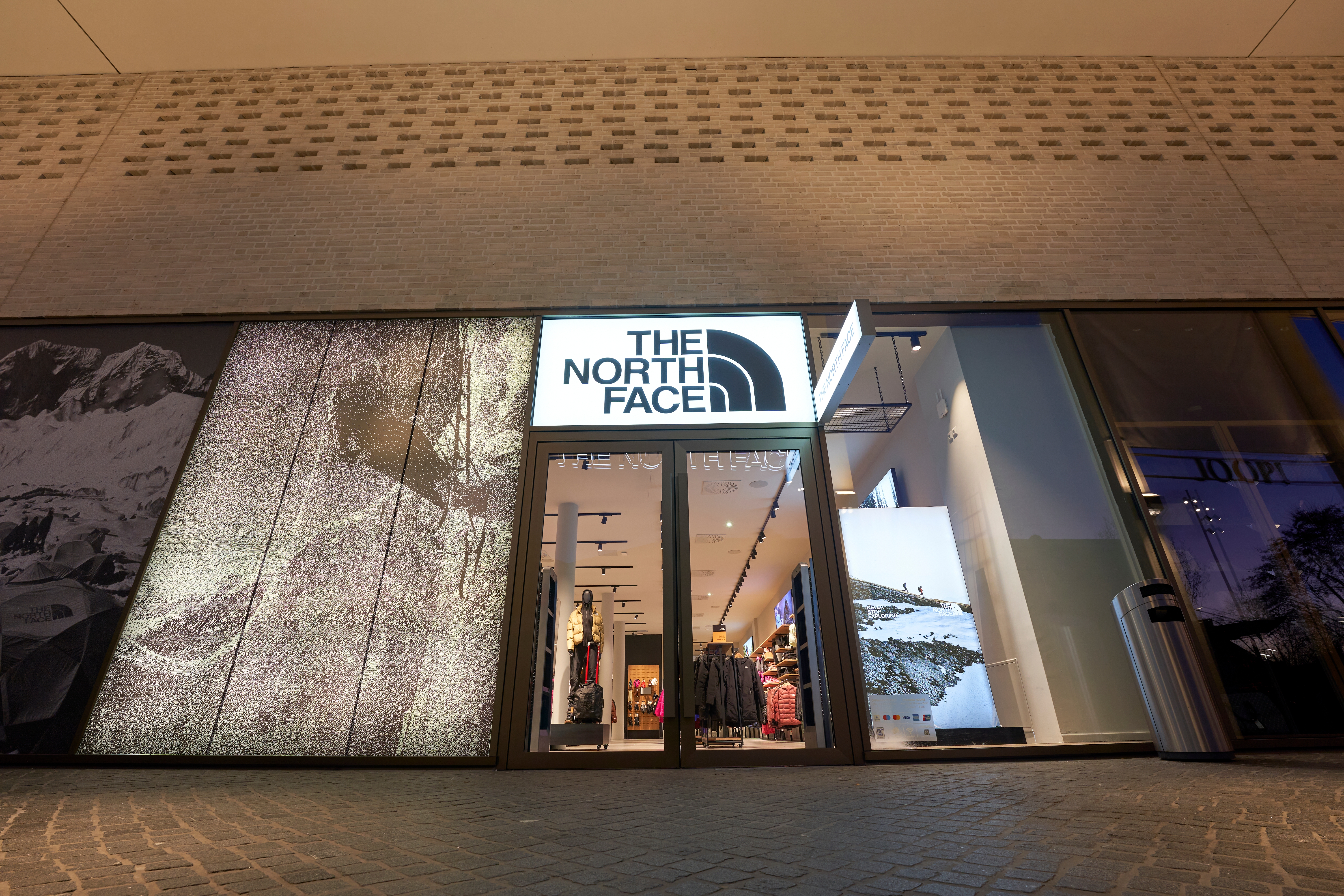 店舗外観。ザ・ノース・フェイスのロゴが店舗入口上部に表示され、店内にはアウトドア用品や衣類が陳列されている。