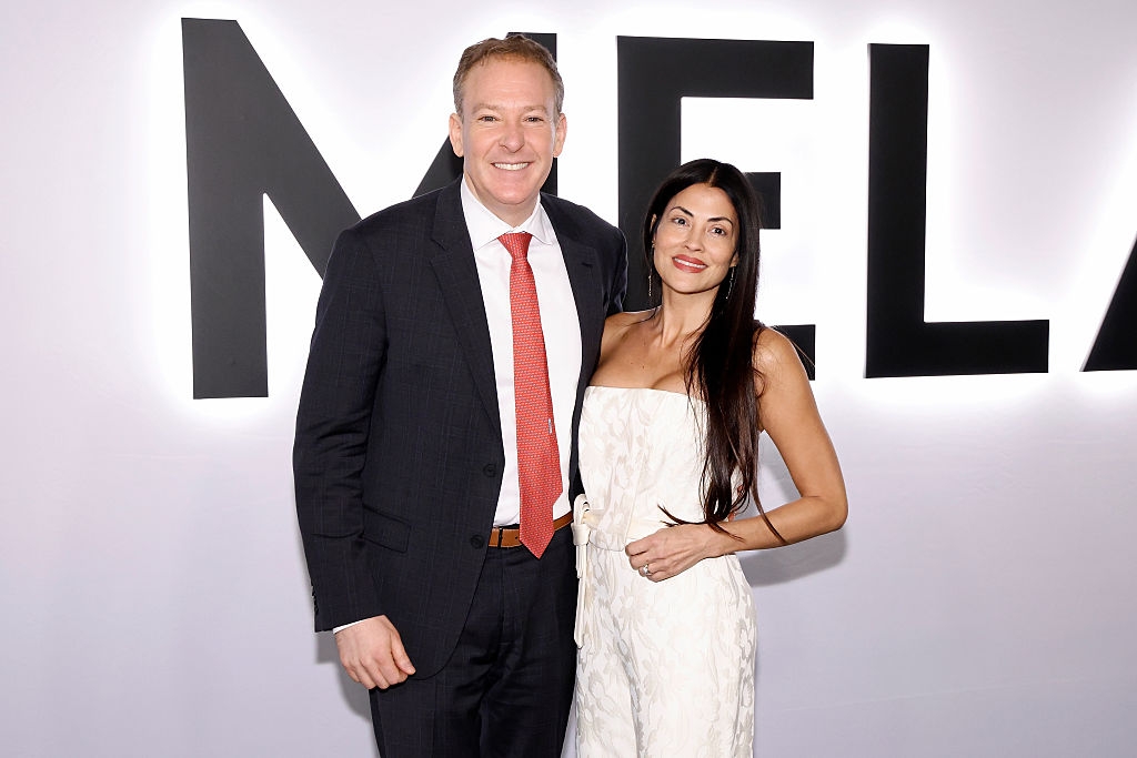 En mann i dress og slips står sammen med en kvinne i en ermeløs, teksturert kjole på en formell begivenhet