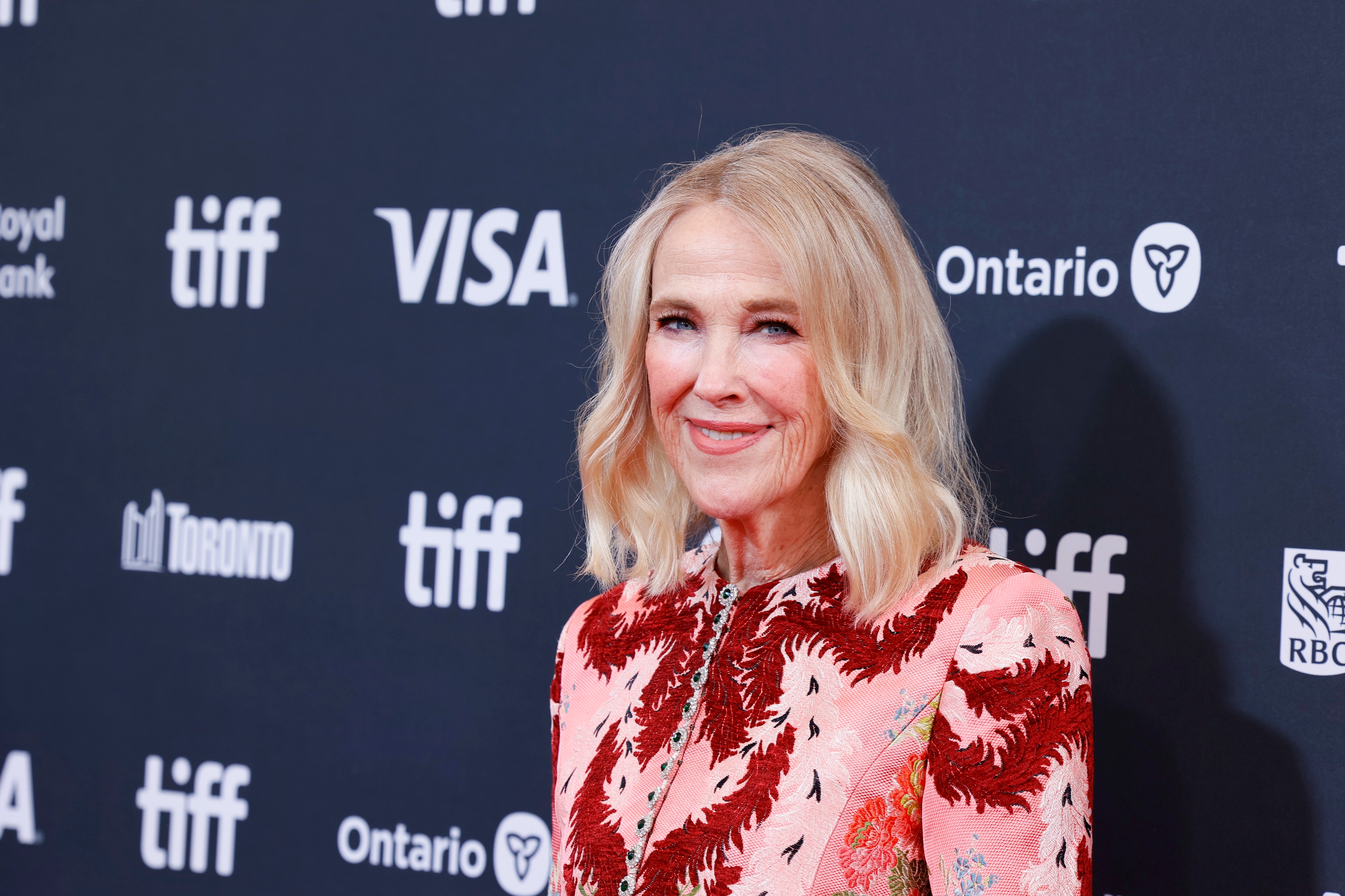 Person in floral-patterned dress on red carpet at the Toronto International Film Festival