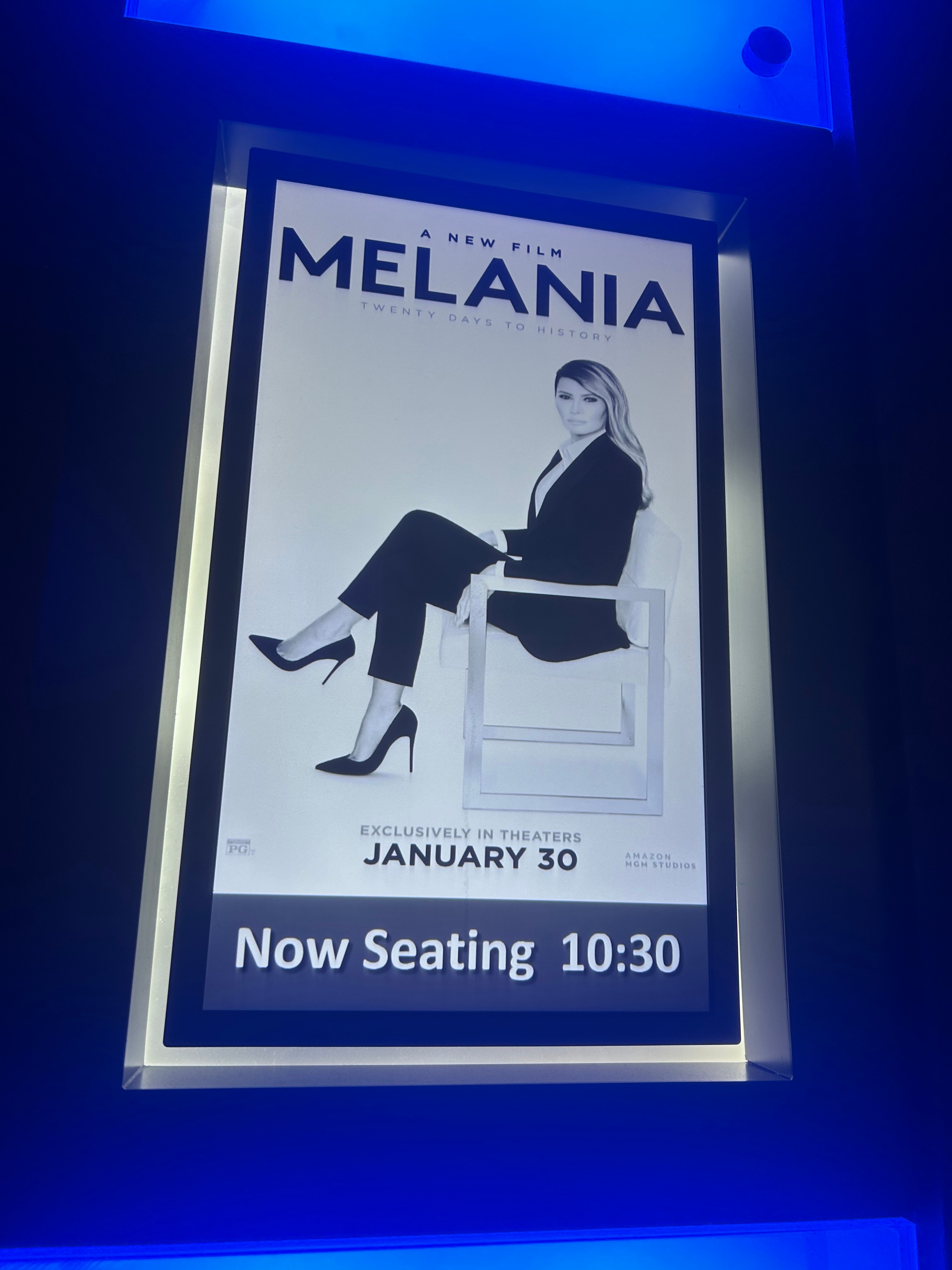 Filmplakat for "Melania: Twenty Days to History" viser en kvinne sittende i en stilig buksedress. Tekstnotater er det nå plass klokken 10:30 30. januar