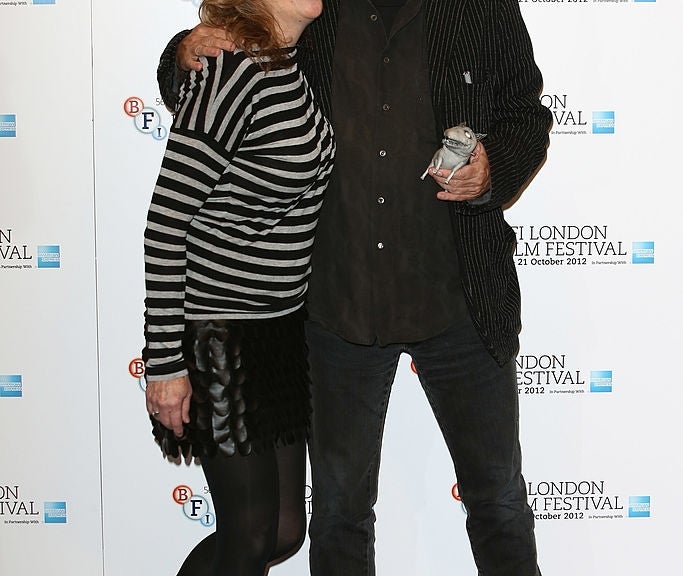Two radical   posing astatine  BFI London Film Festival; 1  wears a striped apical  and skirt, the different   a acheronian  garment  with glasses, some  smiling and casual