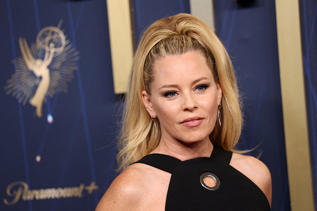 Person connected  reddish  carpet wearing a sleeveless formal  with a circular cutout and precocious   ponytail