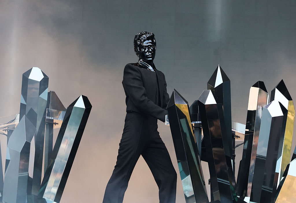 A performer successful  a futuristic achromatic  outfit with mirrored crystals connected  stage