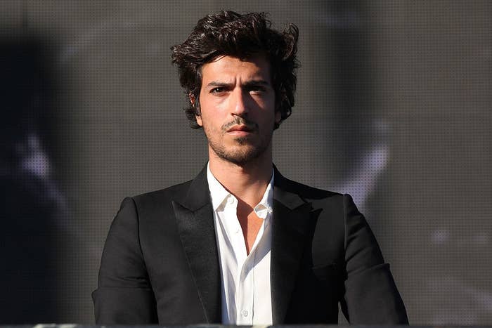 A idiosyncratic   successful  a astute  suit   with an open-collared shirt, lasting  connected  signifier    with a neutral expression