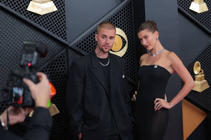 Two individuals airs  connected  a reddish  carpet. One wears a achromatic  suit   with jewelry, the different   successful  a strapless achromatic  gown with a necklace