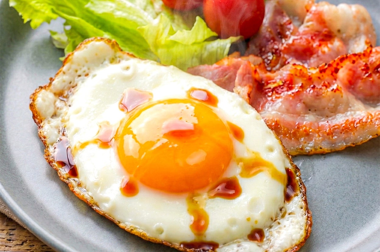 目玉焼き、サラダ、ベーコンが盛られた食欲をそそるプレート。