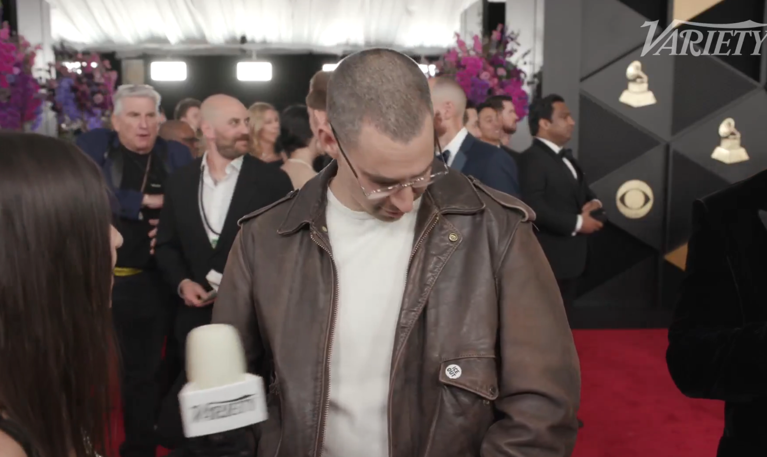 Jack ser ned på en "ICE OUT" stift på skinnjakken hans under et intervju med den røde løperen