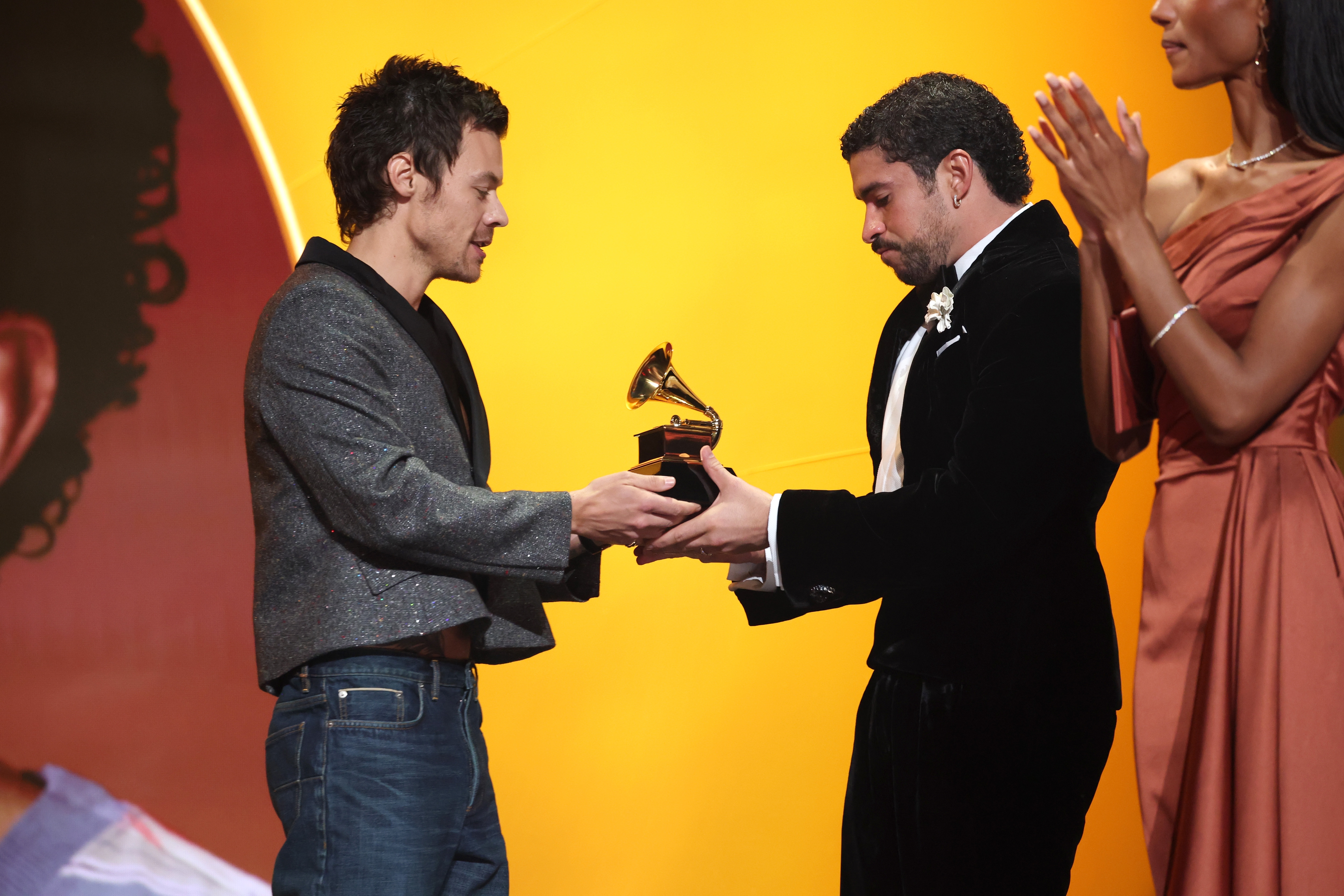 Two individuals connected  signifier    speech   a Grammy award; 1  successful  a casual outfit, the different   successful  a velvet suit, portion    a 3rd  idiosyncratic   claps