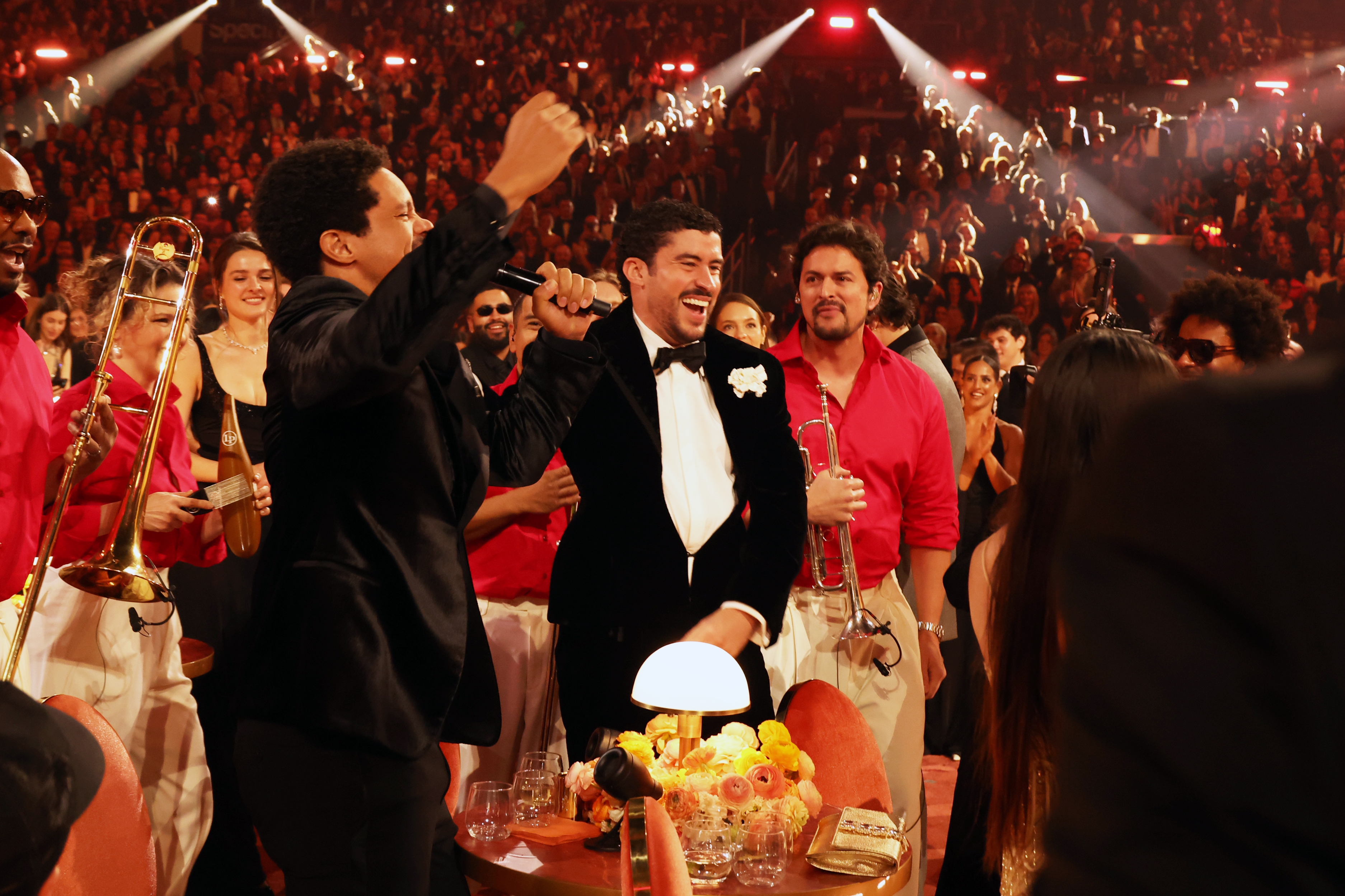 Group of musicians celebrating and smiling astatine  an event, with attendees applauding and a festive atmosphere