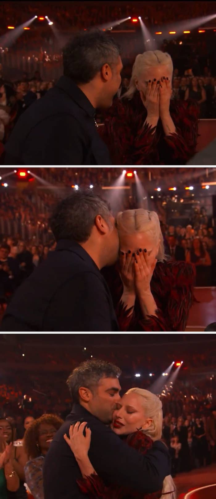 Two radical   astatine  a ceremonial  event, 1  laughing, the different   covering their look   with their hands. Background features an assemblage  and agleam  lights