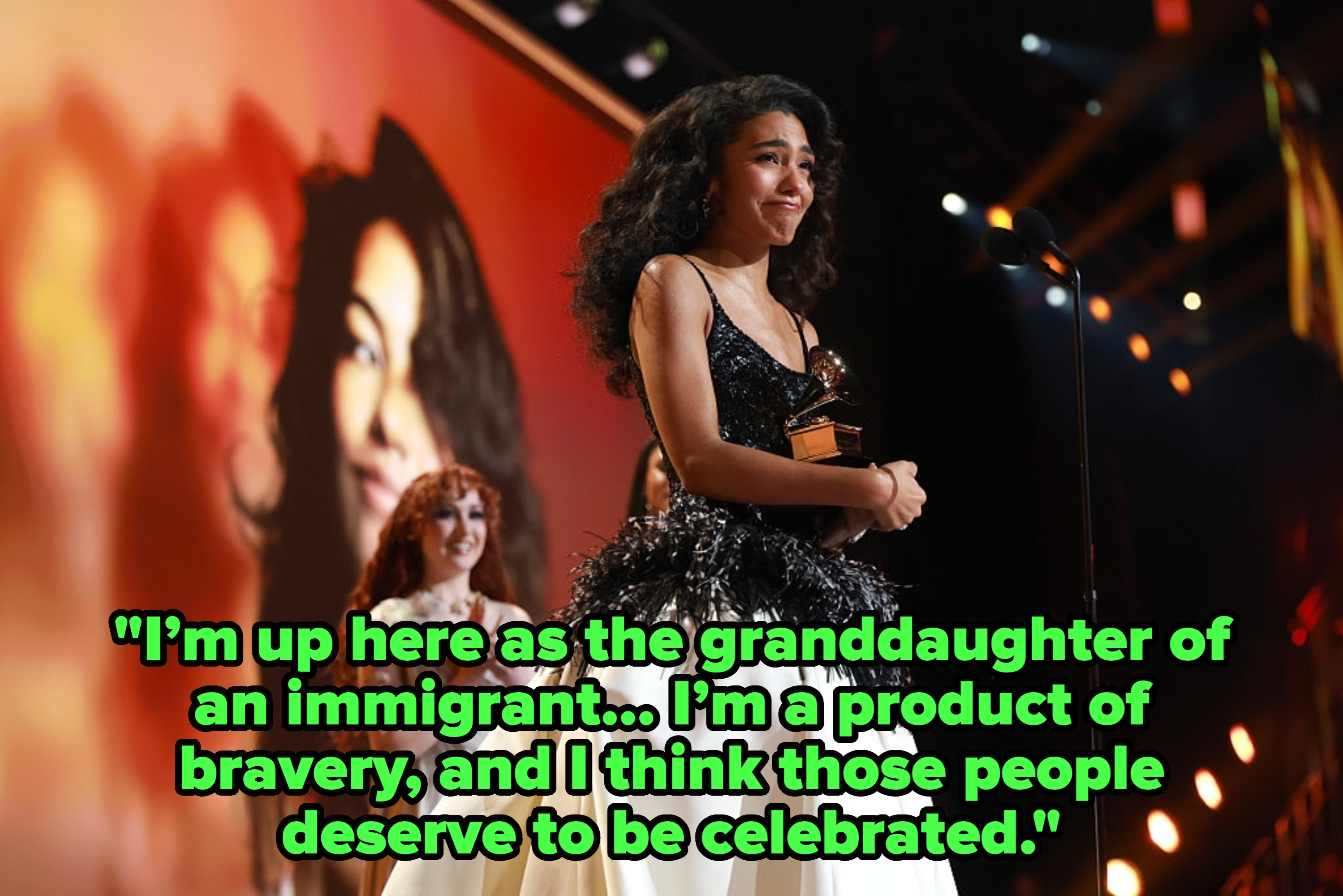 Celebrity successful  a glamorous gown with a feathered apical  holds a trophy connected  stage, smiling. Large surface  with her representation  successful  the background