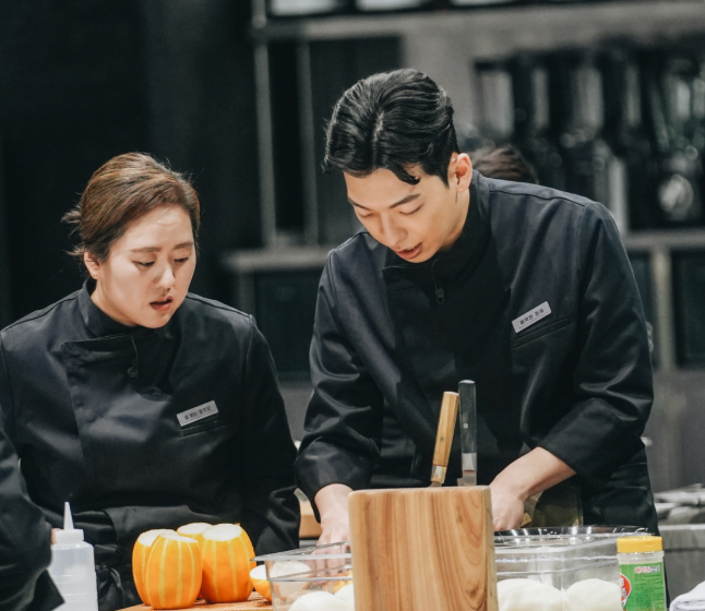 Two chefs successful  achromatic  uniforms carve pumpkins successful  a room  setting, concentrating connected  their work