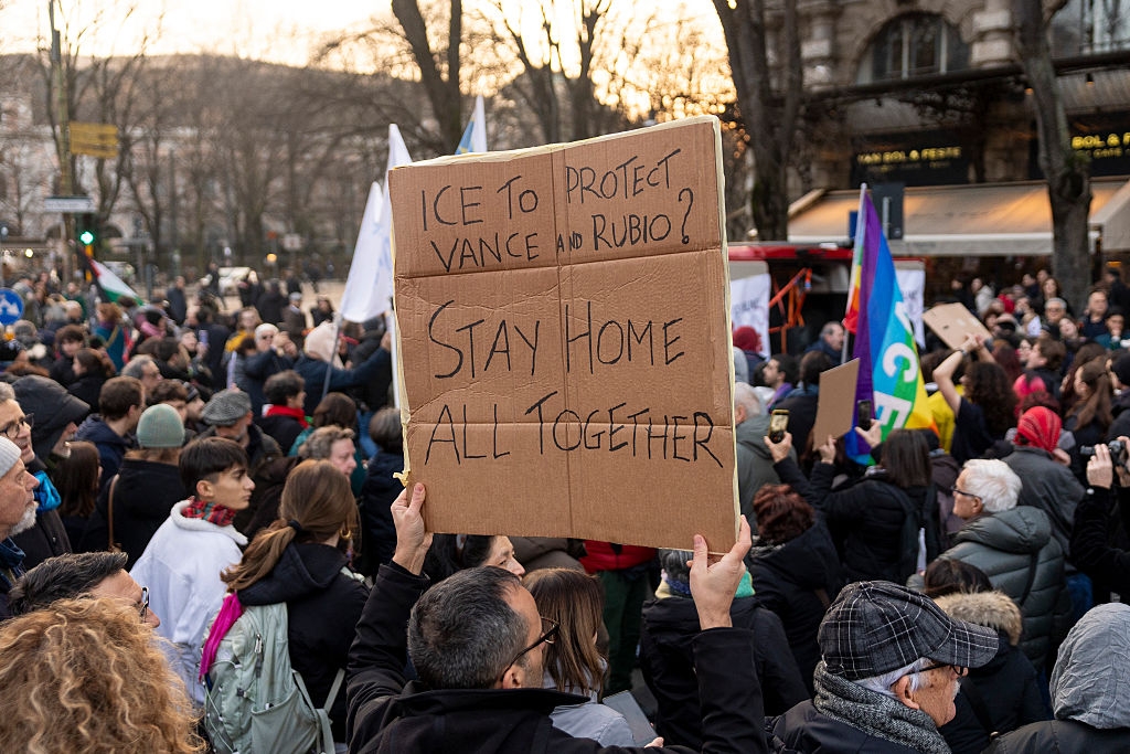 En folkemengde samlet seg utendørs, en person holdt et skilt med 