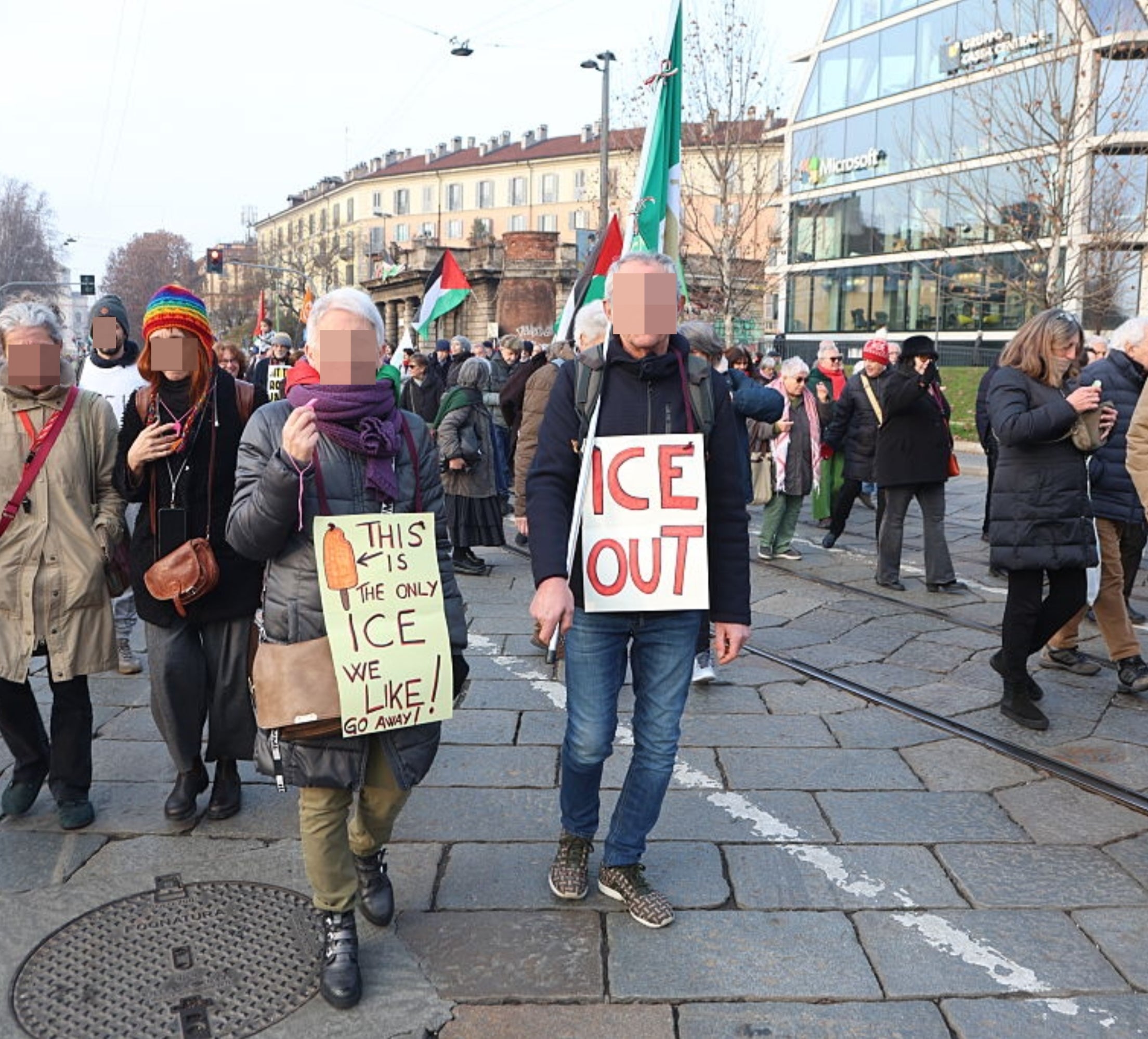 Folk som marsjerer i en protest. To hold-skilt som leser, 