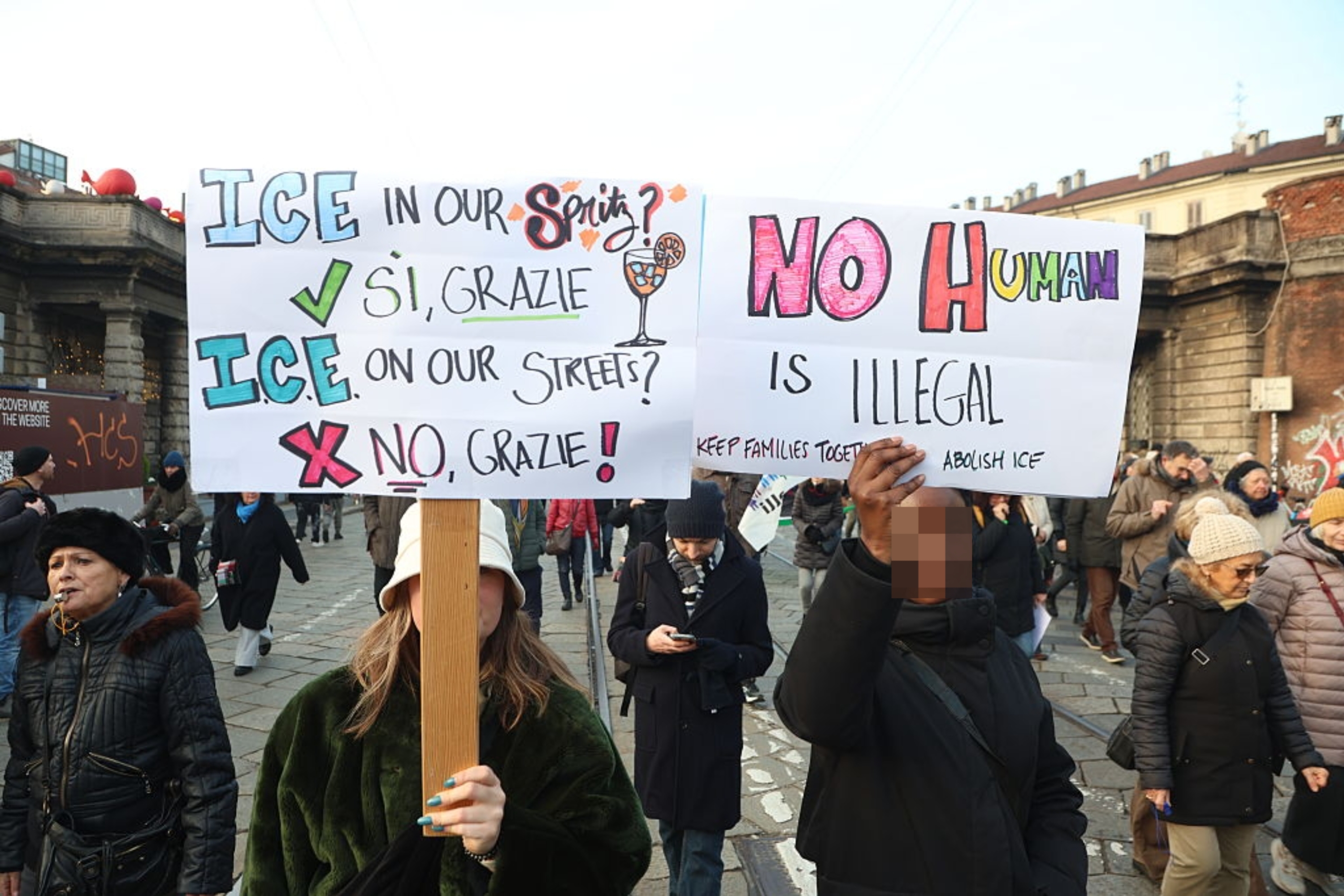 To personer holder skilt ved en protest. Man leser 