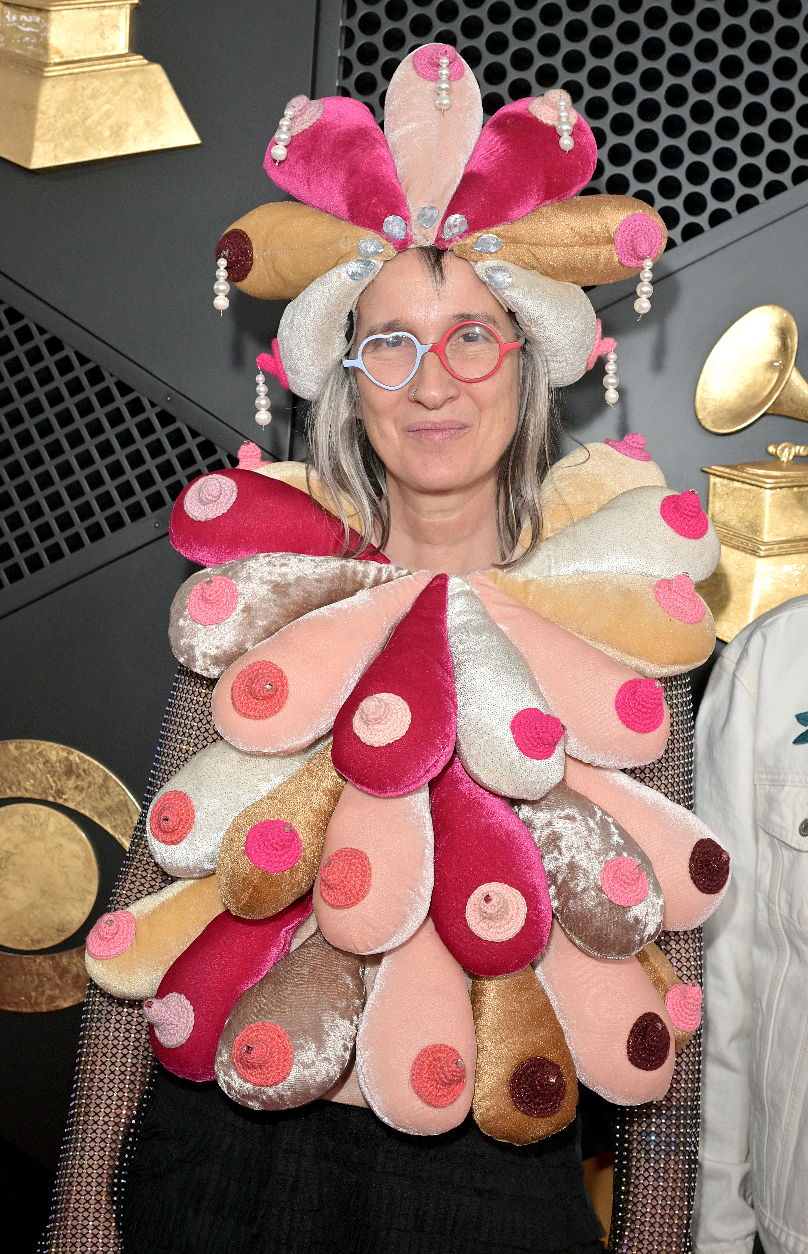 Andrea Echeverri astatine  a ceremonial  lawsuit   wearing a formal  with plush, abstract breast-like shapes