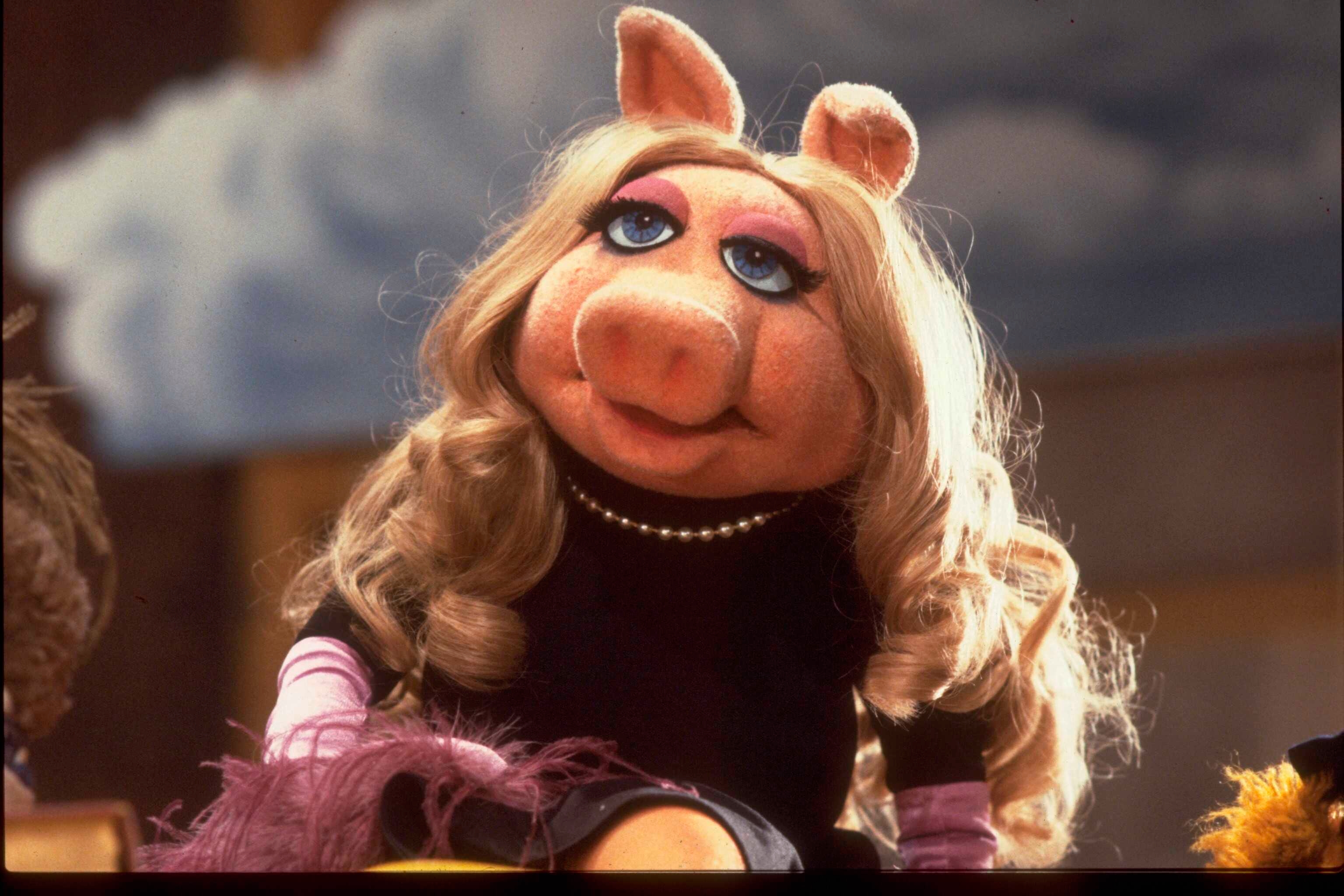 Miss Piggy with curly hairsbreadth and a pearl necklace sits confidently, exuding benignant and charm