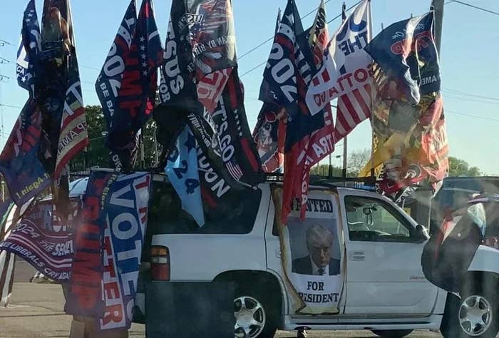 SUV covered with galore   governmental  flags and posters supporting a statesmanlike  candidate, parked connected  a street
