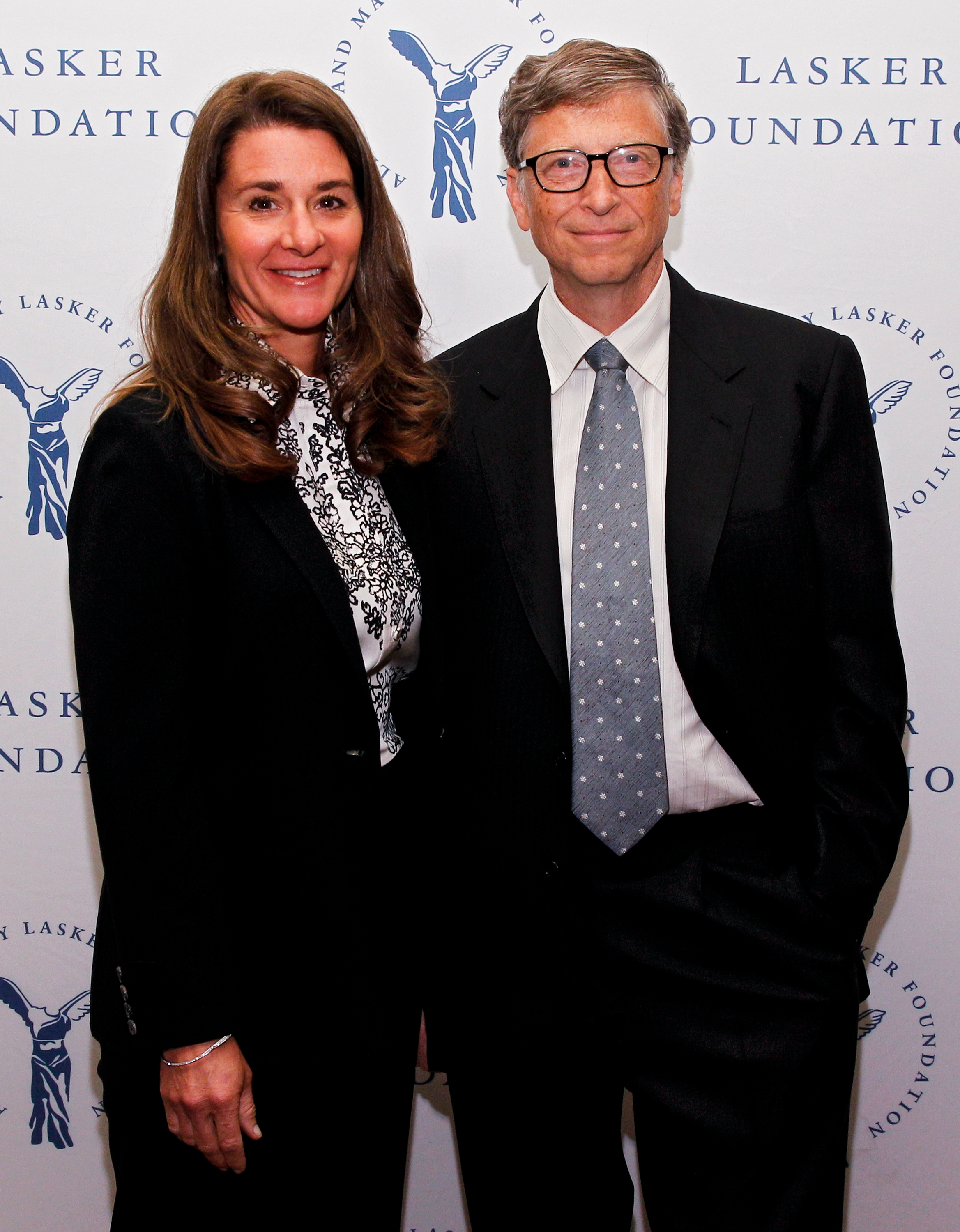 To personer i formell antrekk står foran et bakteppe med "Lasker Foundation" gjentatt, poserer for et begivenhetsbilde